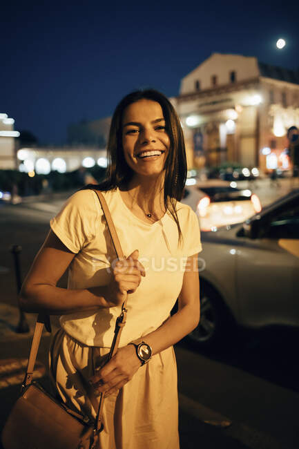 Junge lächelnde Frau in der Nacht in der Stadt — Stockfoto