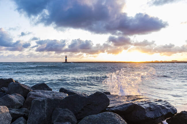 Germania, Meclemburgo-Pomerania occidentale, Warnemunde, Faro e mare al tramonto — Foto stock