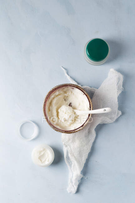 Gauze and bowl of homemade shea butter moisturizer — Stock Photo