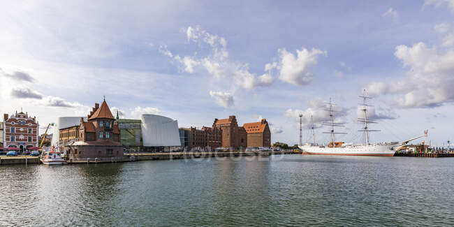 Germania, Meclemburgo-Pomerania occidentale, Stralsund, Lungomare della città costiera con la nave Gorch Fock ormeggiata sullo sfondo — Foto stock