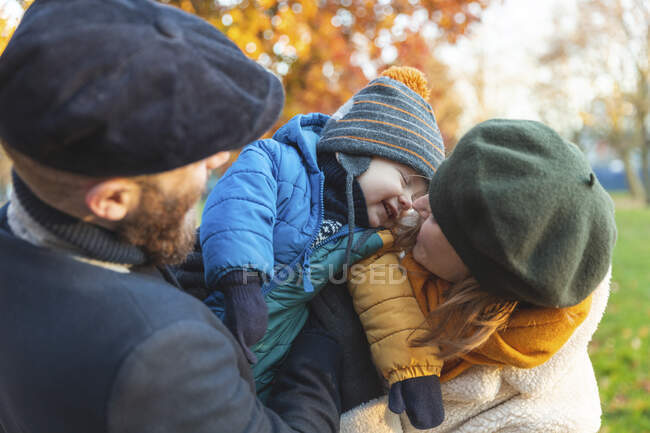 Feliz pareja cariñosa con bebé hijo en el parque - foto de stock