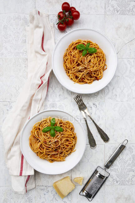 Plates of spaghetti with tomato sauce, Parmesan cheese and basil — Stock Photo