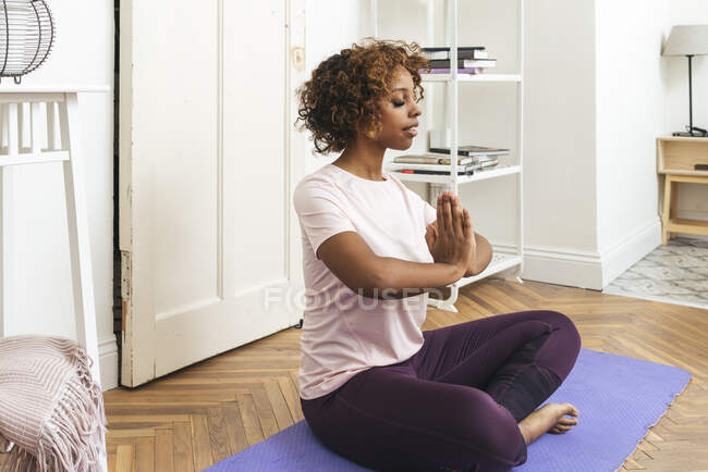 Mujer joven practicando yoga en casa - foto de stock