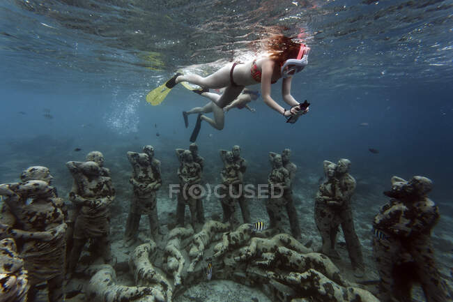 Frauen schwimmen in der Nähe von Unterwasserskulpturen von Jason deCaires Taylor, Insel Gili Meno, Bali, Indonesien — Stockfoto