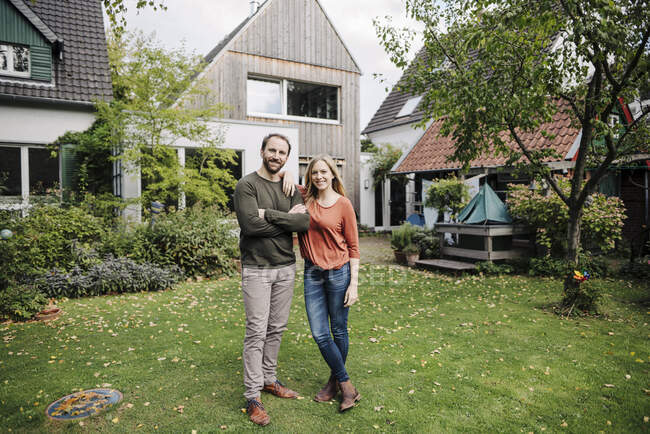 Orgullosos propietarios de viviendas de pie en su jardín - foto de stock