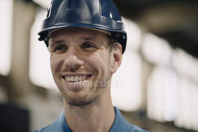 Портрет усміхненого робітника на фабриці з твердим капелюхом. — стокове фото