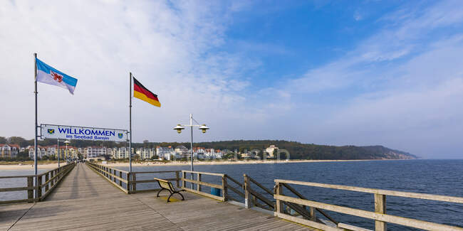 Німеччина, Мекленбург-Західна Померанія, Герінгсдорф, Ласкаво просимо підписати між національними прапорами на дерев'яному пірсі — стокове фото