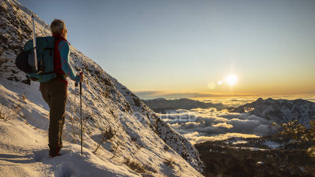 Montañista en la ladera de la montaña durante el amanecer, Orobie Alps, Lecco, Italia - foto de stock