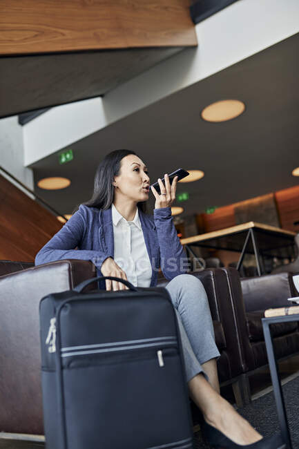 Mujer de negocios usando smartphone en el vestíbulo del hotel — Stock Photo
