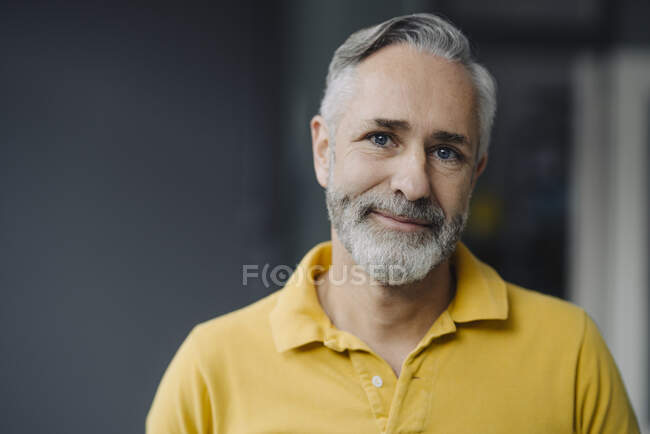 Portrait of smiling mature man with grey beard and blue eyes — Stock Photo