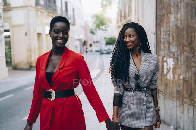 Due donne che si tengono per mano in città — Foto stock