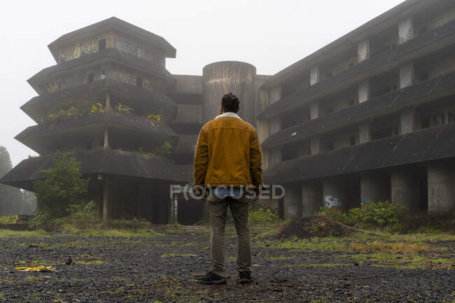 Vista trasera del hombre parado en un edificio abandonado, Isla de Sao Miguel, Azores, Portugal - foto de stock