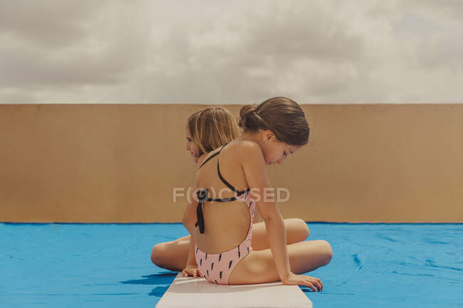 Two girls playing swimmingpool on roof terrace — Stock Photo