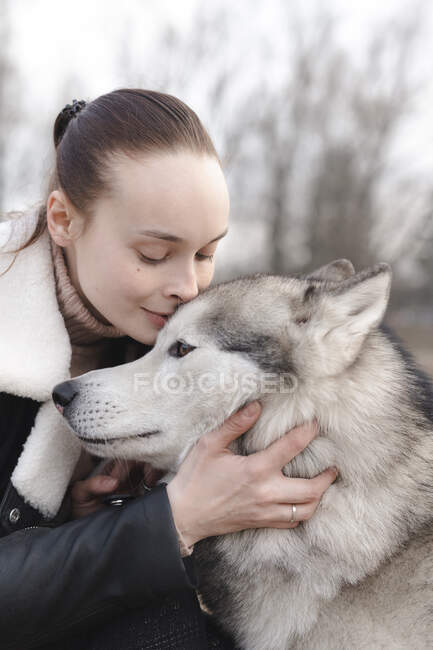 Ritratto di donna che coccola il suo husky — Foto stock