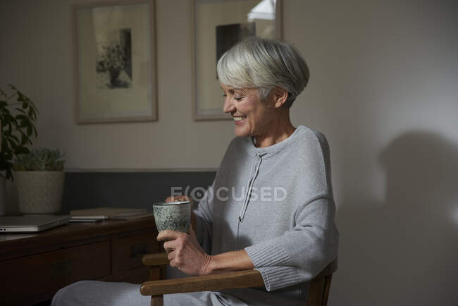 Senior woman relaxing with cup of tea at home — Stock Photo