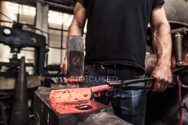 Knife maker working scattering borax over hot damask steel — Stock Photo