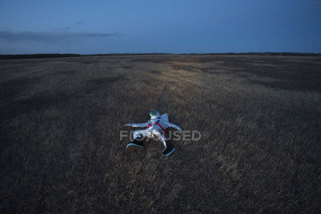 Spacewoman acostado en el prado por la noche - foto de stock