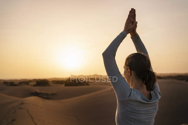 Femme pratiquant le yoga dans les dunes de sable au coucher du soleil, Gran Canaria, Espagne — Photo de stock