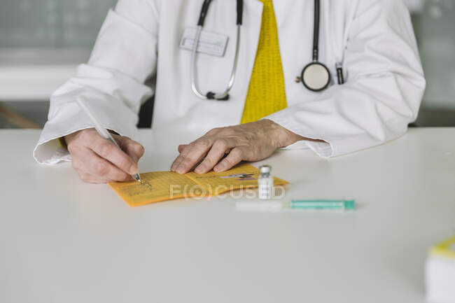 Medico compilando la scheda di immunizzazione — Foto stock