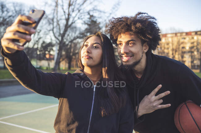 Young sportive couple taking a selfie at sunset — Stock Photo