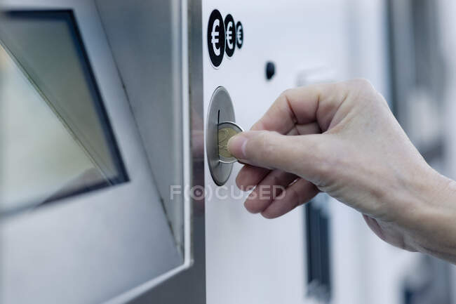 Main de femme mettant pièce dans la machine à payer — Photo de stock