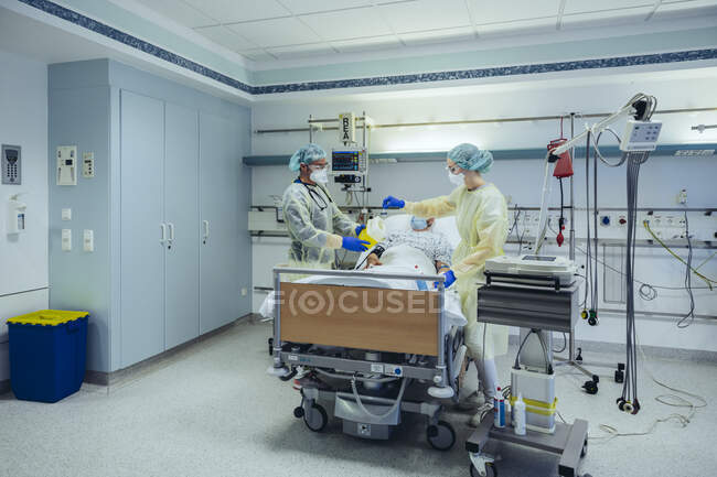 Doctors caring for patient in emergency care unit of a hospital taking blood sample — Stock Photo