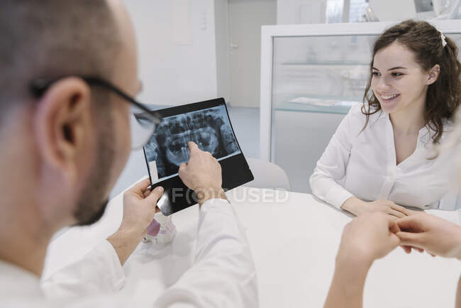 Дантист говорит пациенту о результатах рентгена — стоковое фото