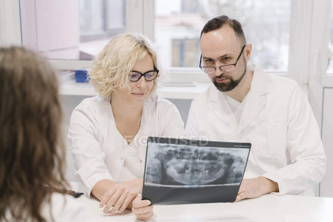 Стоматологи говорять про рентгенівські результати для пацієнта. — стокове фото