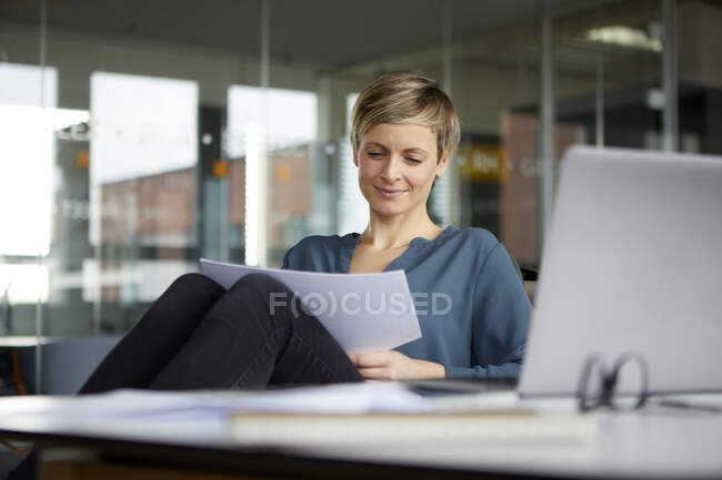 Femme d'affaires souriante travaillant au bureau — Photo de stock