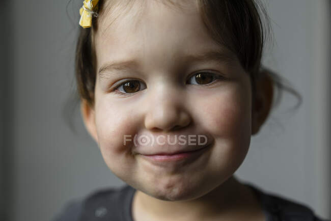 Retrato de niña sonriente con ojos marrones - foto de stock