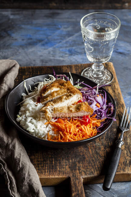 Bowl of ready-to-eat salad with white and red cabbage, carrots, rice and chicken schnitzel — Stock Photo