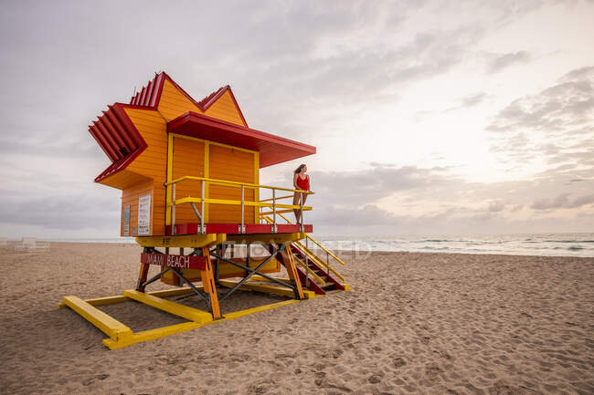 Woman in red swimsuit on lifeguard hut on Miami Beach, Miami, Florida, USA — Stock Photo
