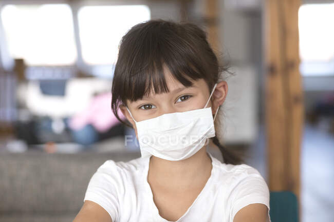 Fille portant un masque à la maison — Photo de stock