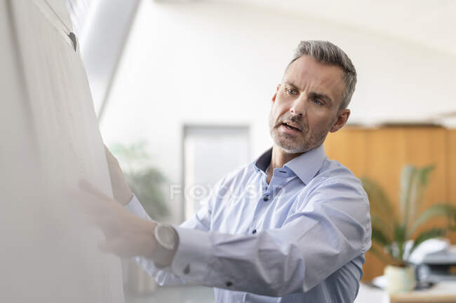 Retrato del empresario explicando el plan en el cargo - foto de stock