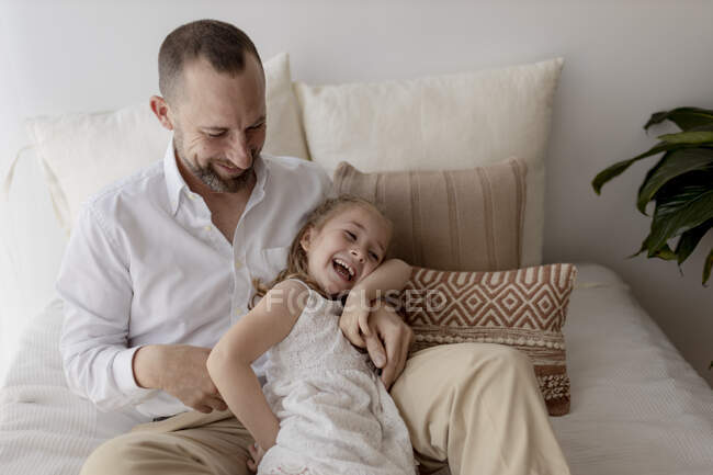 Батько лоскоче свою маленьку доньку — стокове фото