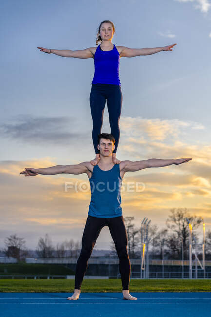 Giovane coppia facendo acrobazie al tramonto — Foto stock