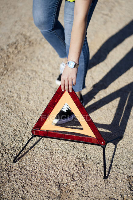 Close-up de mulher postando triângulo de advertência — Fotografia de Stock