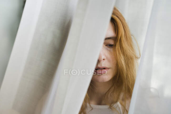 Retrato de una joven triste en una cortina - foto de stock