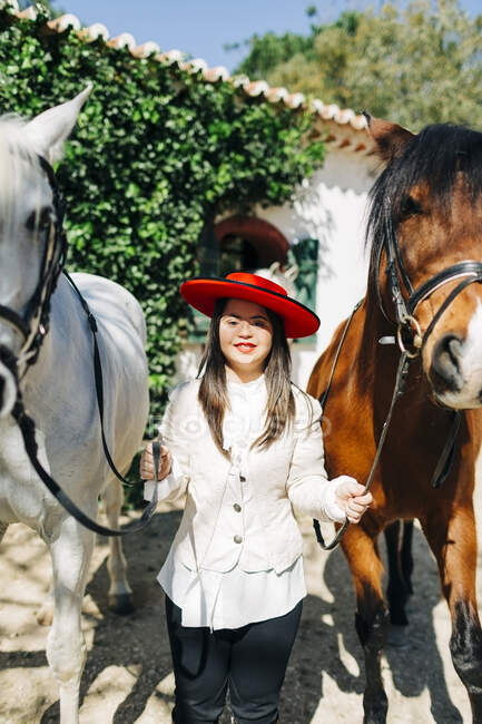 Adolescente con sindrome di Down indossa cappello rosso con due cavalli — Foto stock
