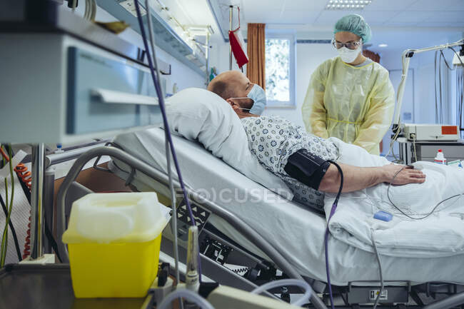 Médecin soignant un patient dans une unité de soins d'urgence d'un hôpital prélevant un échantillon de sang — Photo de stock