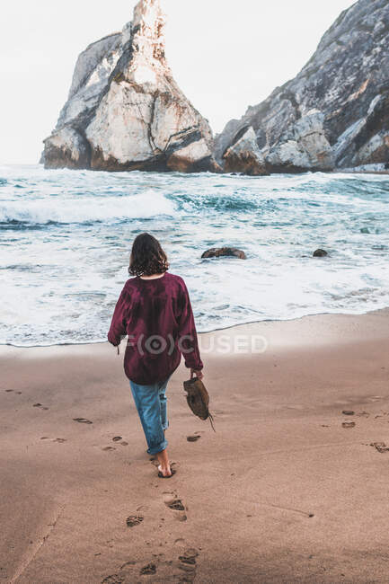 Vue arrière de la jeune femme marchant à Praia da Ursa, Lisboa, Portugal — Photo de stock