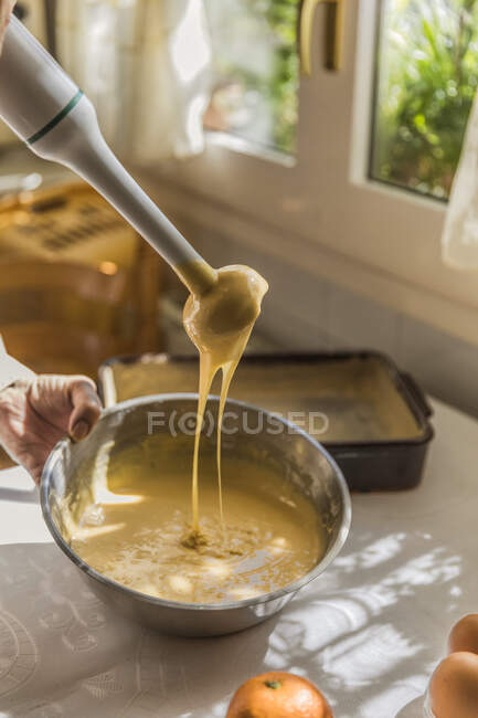 Mano di donna sbattere ingredienti torta con miscelatore elettrico — Foto stock