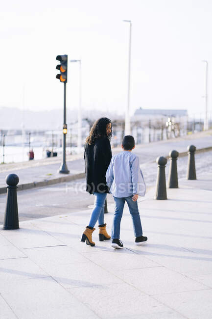 Back view of mother and son walking on pavement — Stock Photo