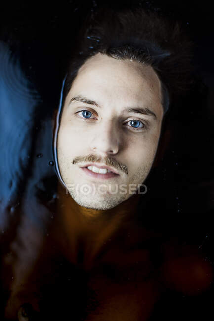 Retrato de un joven con ojos azules en el agua - foto de stock