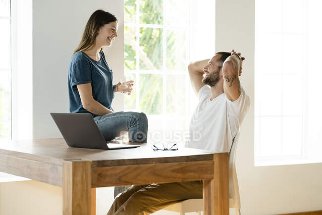 Счастливая пара с ноутбуком в домашнем офисе в современной гостиной — стоковое фото