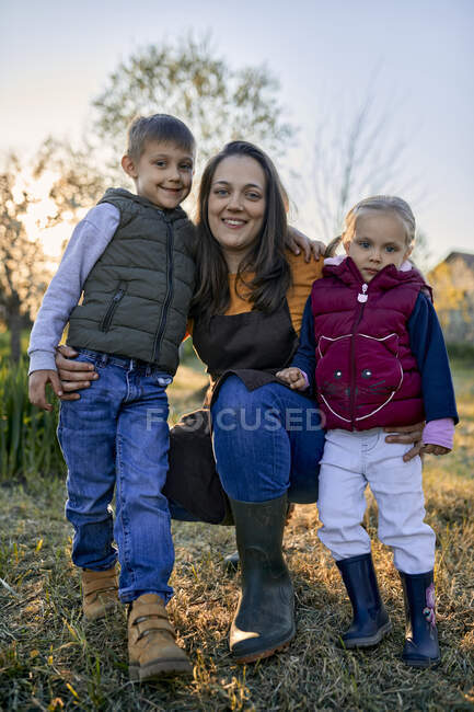 Ritratto di madre felice con due bambini in giardino — Foto stock