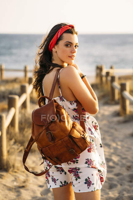 Junges Mädchen mit Ledertasche am Strand — Stockfoto