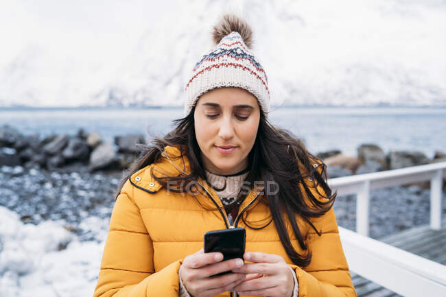 Мбаппе с сотовым телефоном на побережье, Лодзь, Норвегия — стоковое фото