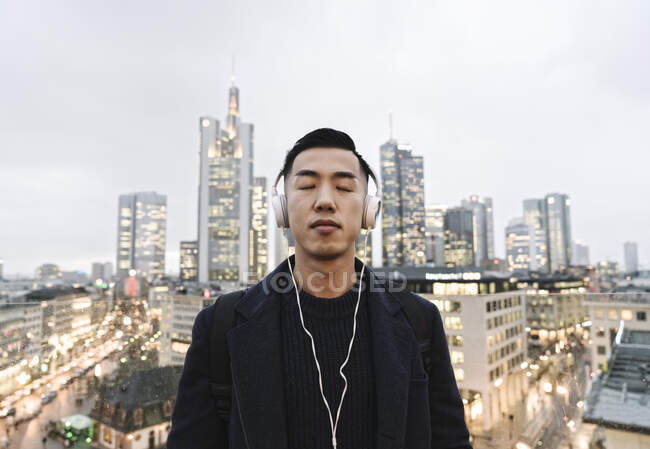 Mann mit Kopfhörern vor der Skyline von Frankfurt — Stockfoto