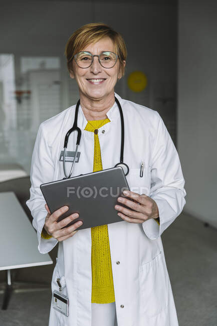 Portrait of smiling doctor holding tablet — Stock Photo